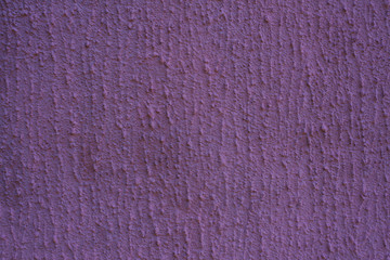 Purple plaster wall. Uneven texture of putty on the wall with copy space