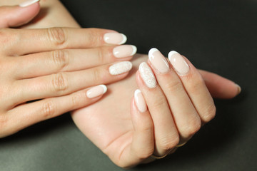 Fashionable gentle manicure gel Polish on natural nails with a white monogram pattern on the hands of a modern girl © verzemnik
