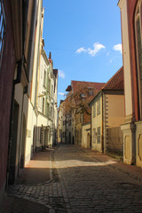 Fototapeta na wymiar Picturesque view of a narrow street somewhere in Old Town of Riga. Empty center of Riga city.