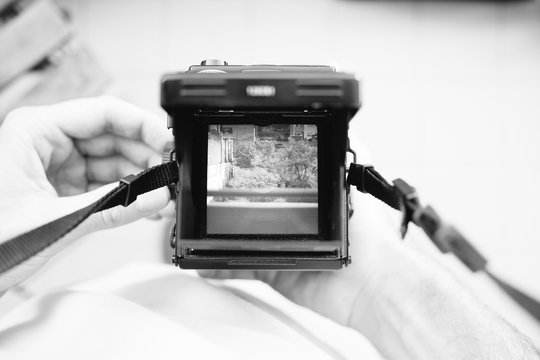 a young man holding a tlr medium format film camera. P