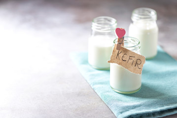 Fermented drink kefir in a glass jar on a light background. Probiotic cold fermented dairy drink.