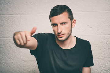 Young man showing his index finger towards the camera