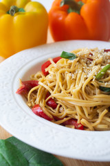 Chinese egg noodles in soy sauce with colorful bell peppers, greens and spring onions with sesame seeds sprinkled on top