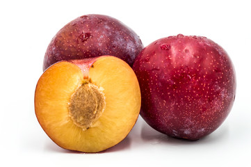 Ripe red round plums and a quarter isolated