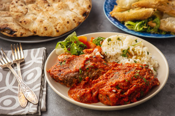 Minced meat cutlets in tomato sauce, served with rice, bifteki-greek cuisine.