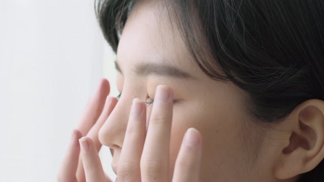 Beautiful young asian woman touch skin smooth of eyes with perfect, girl massaging facial for health with cosmetic, skin care is hydration and rejuvenation with cream or lotion, beauty concept.