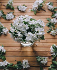 A bouquet of white flowers of an apple tree on a wooden table background. Spring concept.