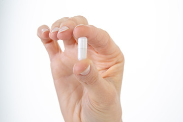A capsule with medicine in a woman's hand.