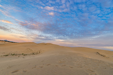 Fototapeta na wymiar Landscape photo of sand dune under blue sky at sunset