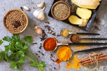 Set of Indian spices and herbs selection on a stone table. Top view flat lay background.