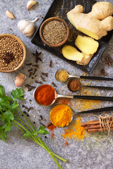 Set of Indian spices and herbs selection on a stone table. Top view flat lay background. Copy space.