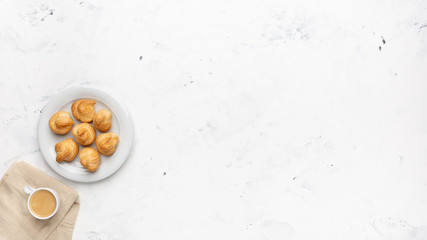 Homemade profiteroles with cream and coffee. Close-up.