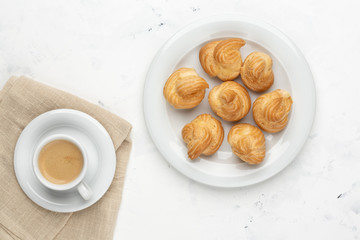 Homemade profiteroles with cream and coffee. Close-up.