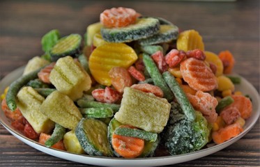 fresh frozen vegetables in a plate on a wooden table