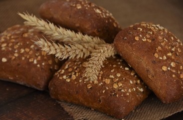 baked rye buns with cereal flakes and ears of wheat