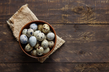 quail eggs in wooden bowl on table top view copy space