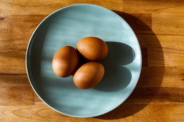 tres huevos frescos en un plato
