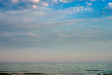 Obraz premium Blue sea surface extending to the horizon under a cloudy sky.