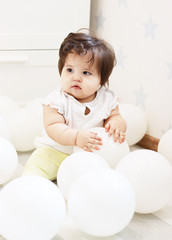 cute baby playing with white inflatable helium balloons