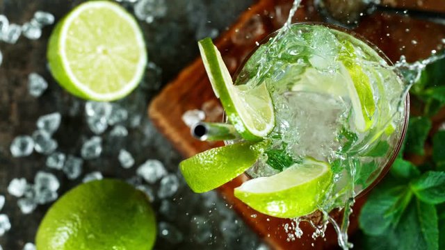 Refreshing mojito cocktail in a glass on black stone table, macro super slow motion filmed on high speed cinematic camera.