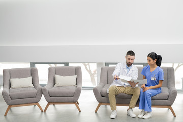 Bearded young clinician showing card or prescription of one of his patients