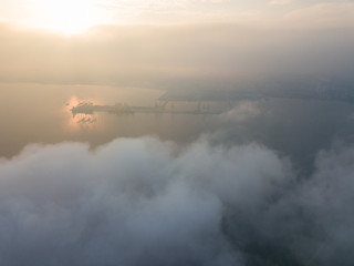 Obraz na płótnie Canvas Aerial view Container Terminal in early morning over sea cloud.