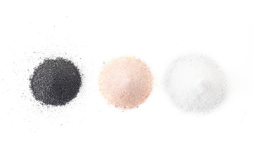 three types of salt lie on a white background - black, pink, white
