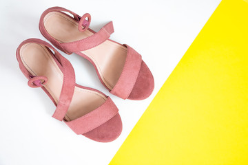 Women's summer shoes in pink on a white and yellow background. Elegant high-heeled shoes. Top view.