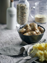  Swedish meatbals with cream sauce and mashed potato on a rustic wooden surface