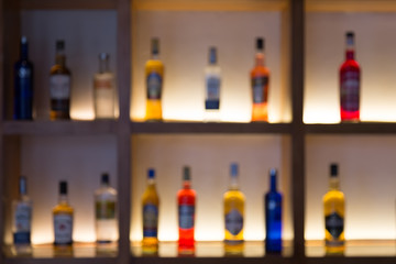 Defocused background of various alcohol bottles in a bar or restaurant. Bar advertisement mockup...