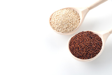 in wooden spoons on a white background are the seeds of white and red quinoa