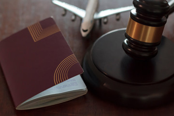 Judge's gavel, passport and airplane. Concept of international law, immigration law and citizenship...