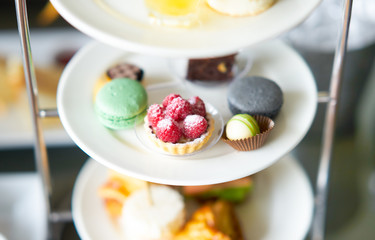 raspberry mini pie and macaron and chocolate on plate stand