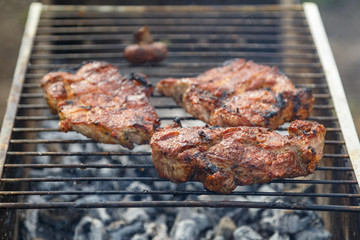 The process of cooking barbecue steaks on an open fire.