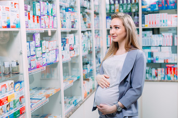 A beautiful pregnant woman consults at a pharmacy.