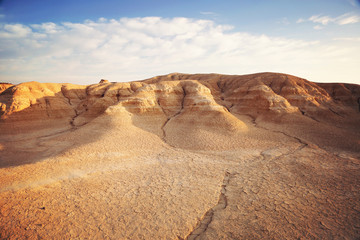 Fototapeta premium Sunset on a land plain eroded by water, where in the background you can see small red mountains with iron oxides. It is like a desert land in the north of Spain.