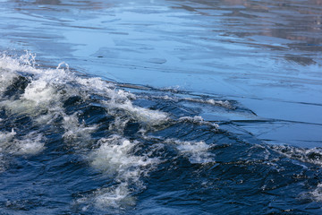 Blue Art. Water Banner. Liquid Ice. Icy Pattern. Ocean Texture. Abstract magical Ice. blue water surface with thin pieces of ice. close-up: thin sheets of ice on the water break from the wave
