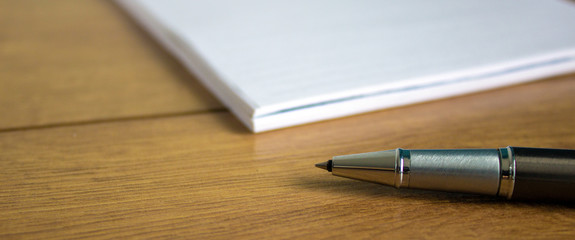 notebook and pen on wood table