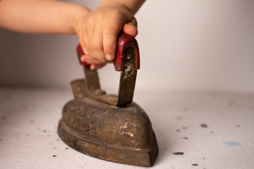 Children's hands on the red iron handle