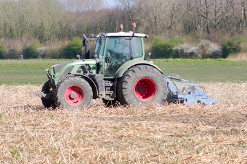 Farmer on tractor works on the field in Arnhem, Netherlands