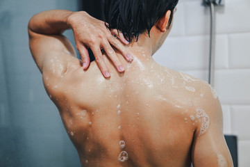 Closeup handsome asian man taking a shower in the bathroom ,vintage tone, selective focus