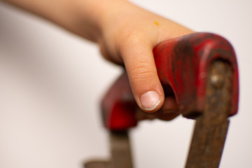 Children's hands on the red iron handle