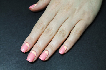 Beautiful female hand with manicure coral gel Polish and hand drawn design