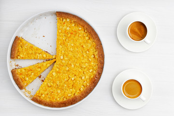 Homemade Apple Lemon Pie and two cup of coffee espresso on white wooden table.