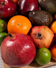 Pomegranates, avocados, mandarins, apples and lime.
