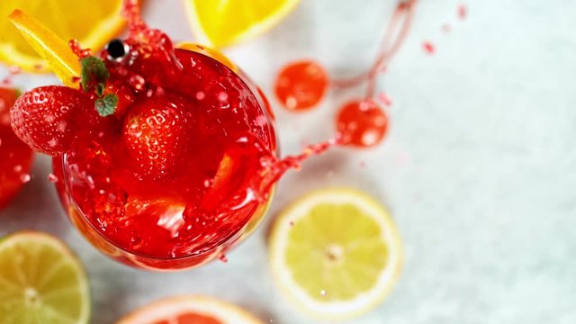 Refreshing fruit sangria cocktail in a glass on white stone table, macro super slow motion filmed on high speed cinematic camera.