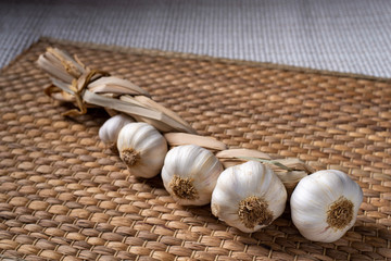 Unpeeled garlic beautifully intertwined on a brown background.