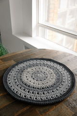 Knitted round carpet or rug. Antique handmade carpet. Home hobby. Closeup knitted carpet texture