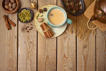 Masala chai tea traditional indian drink  with milk and spices on wooden background. Top view from...
