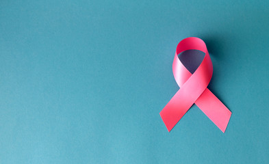 Breast cancer concept. Pink symbolic tape ribbon on blue background.